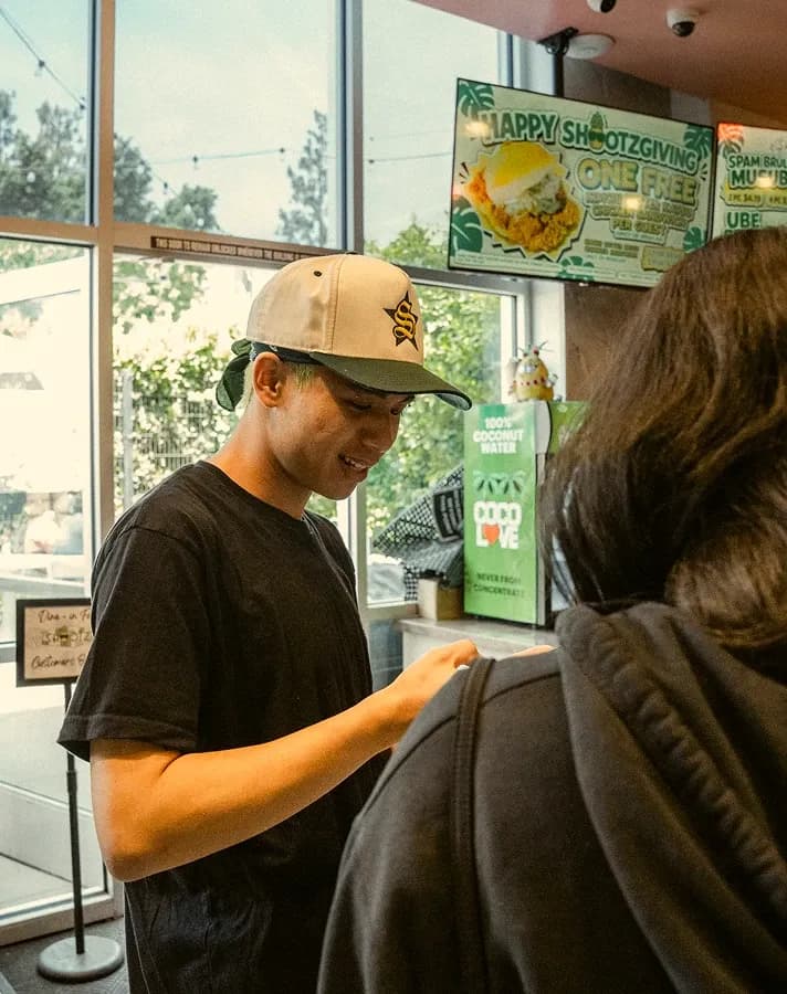 A crew member helping a guest at the front counter